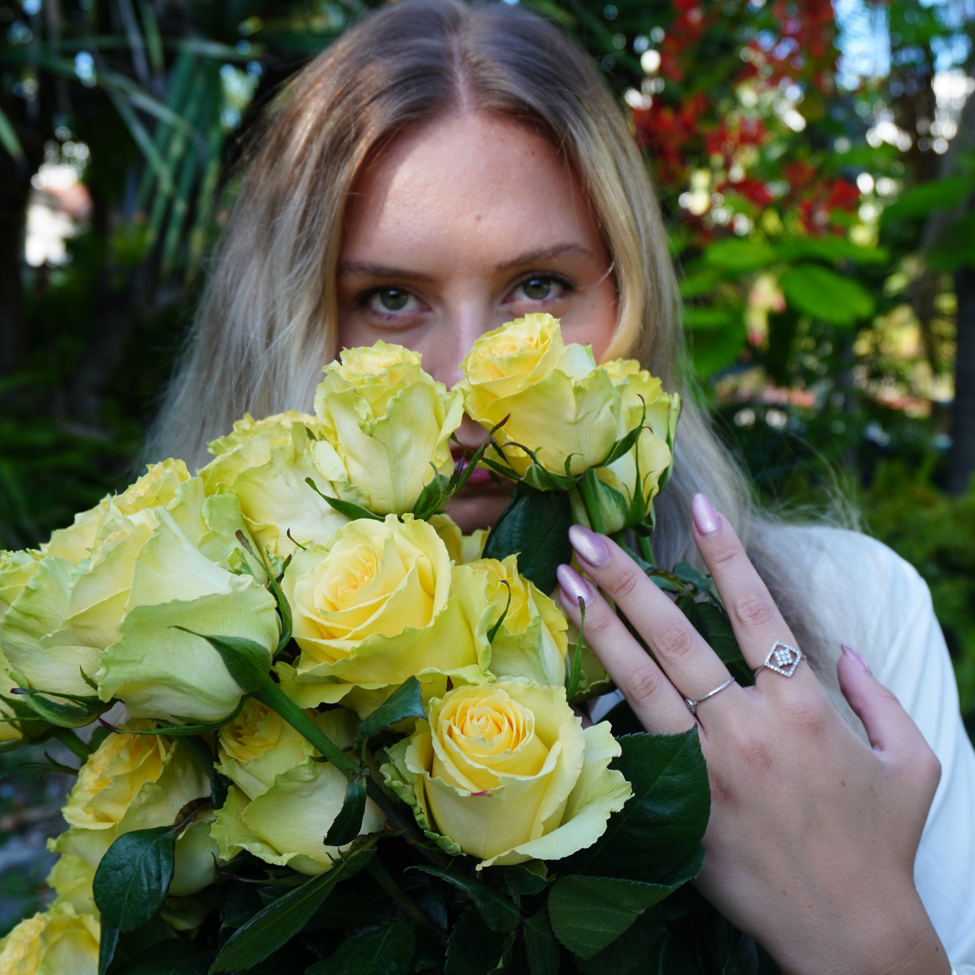 Woman holding a bouquet of yellow flowers with a blurred natural background