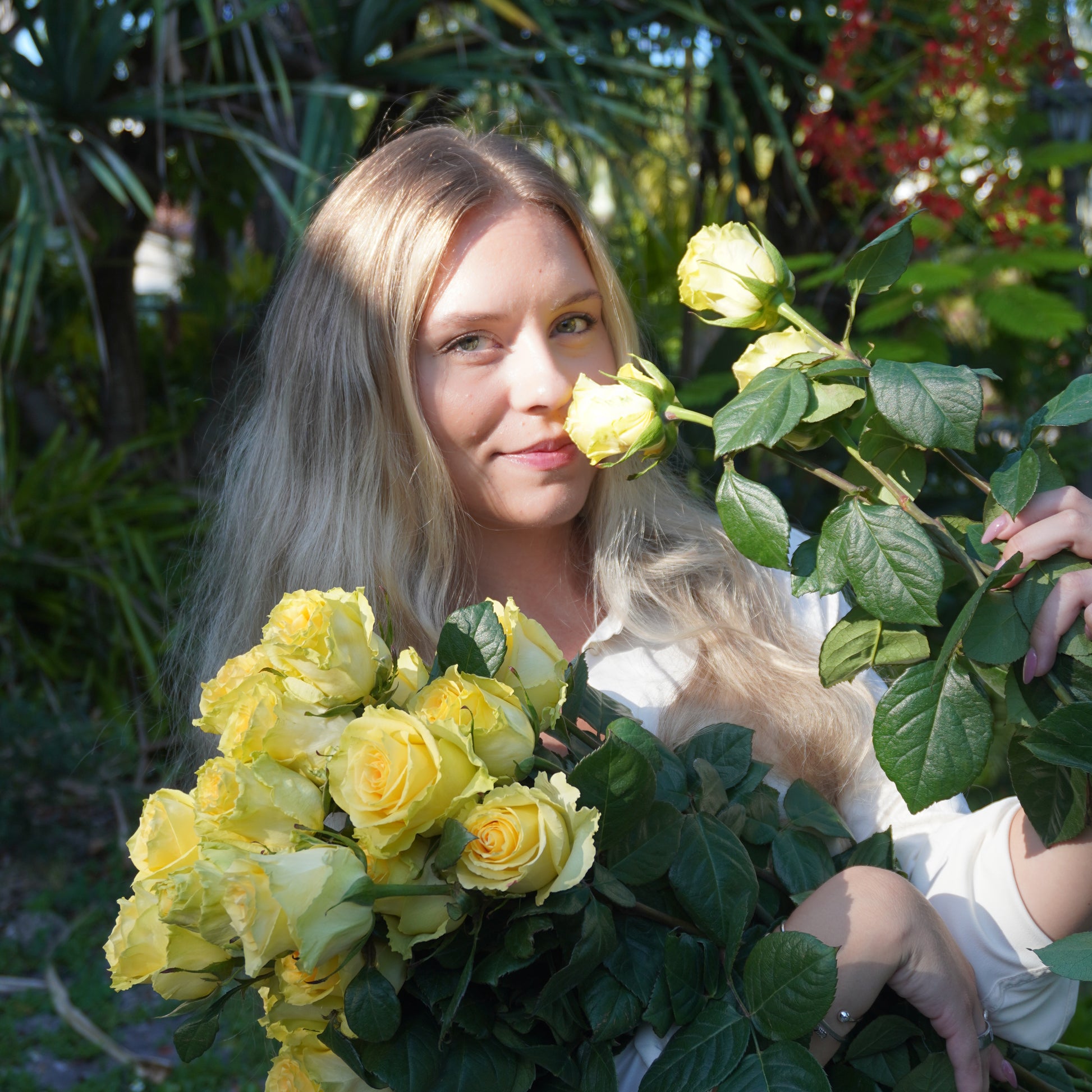 Woman surrounded by yellow roses and greenery
