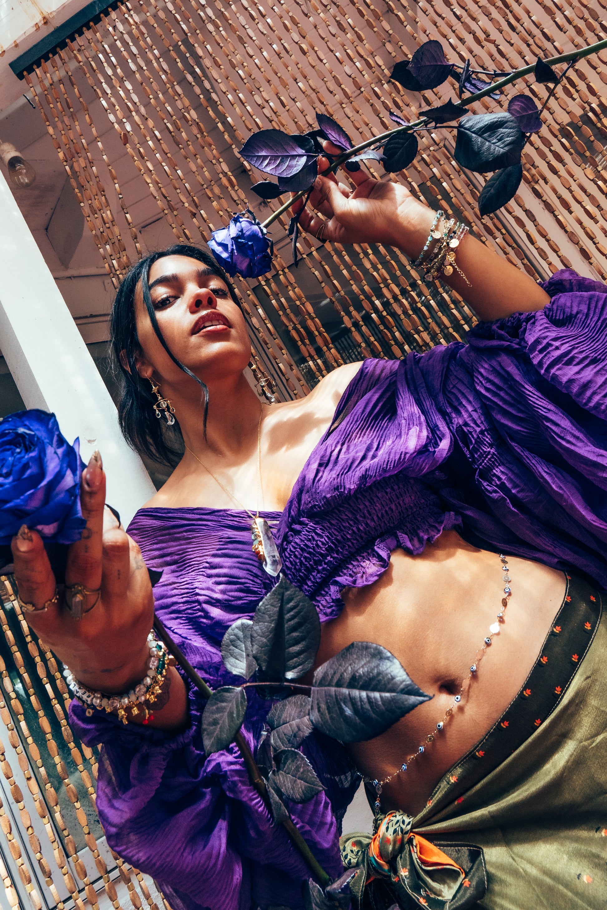 Woman in a purple dress holding flowers on a textured surface