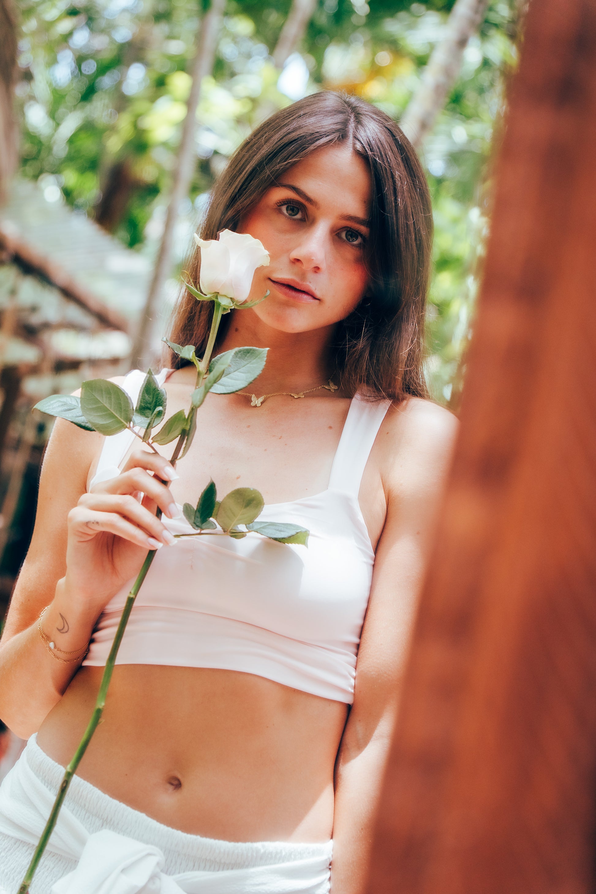 Woman holding a pink rose in a natural setting