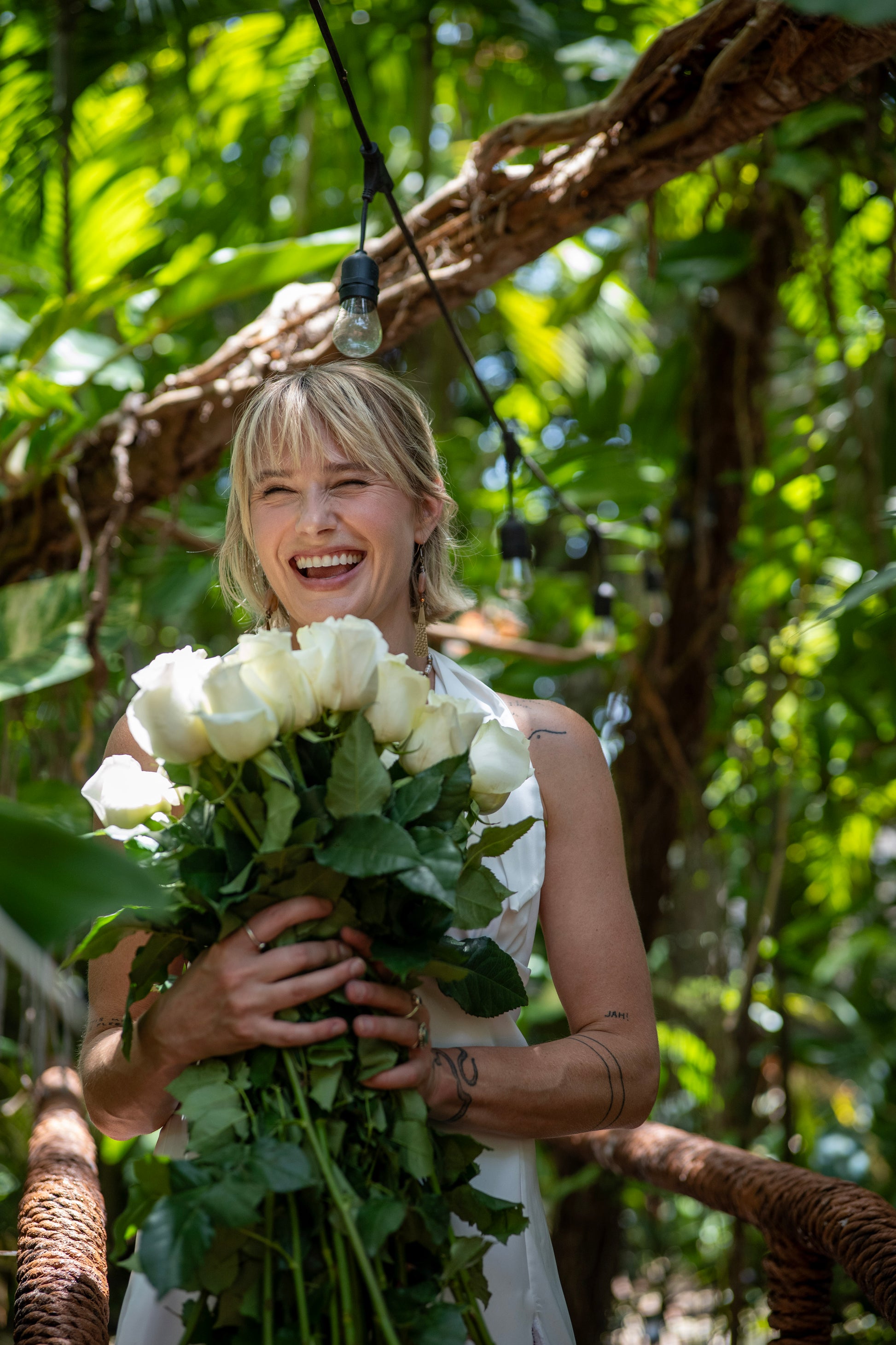 Woman holding white roses in a forest setting