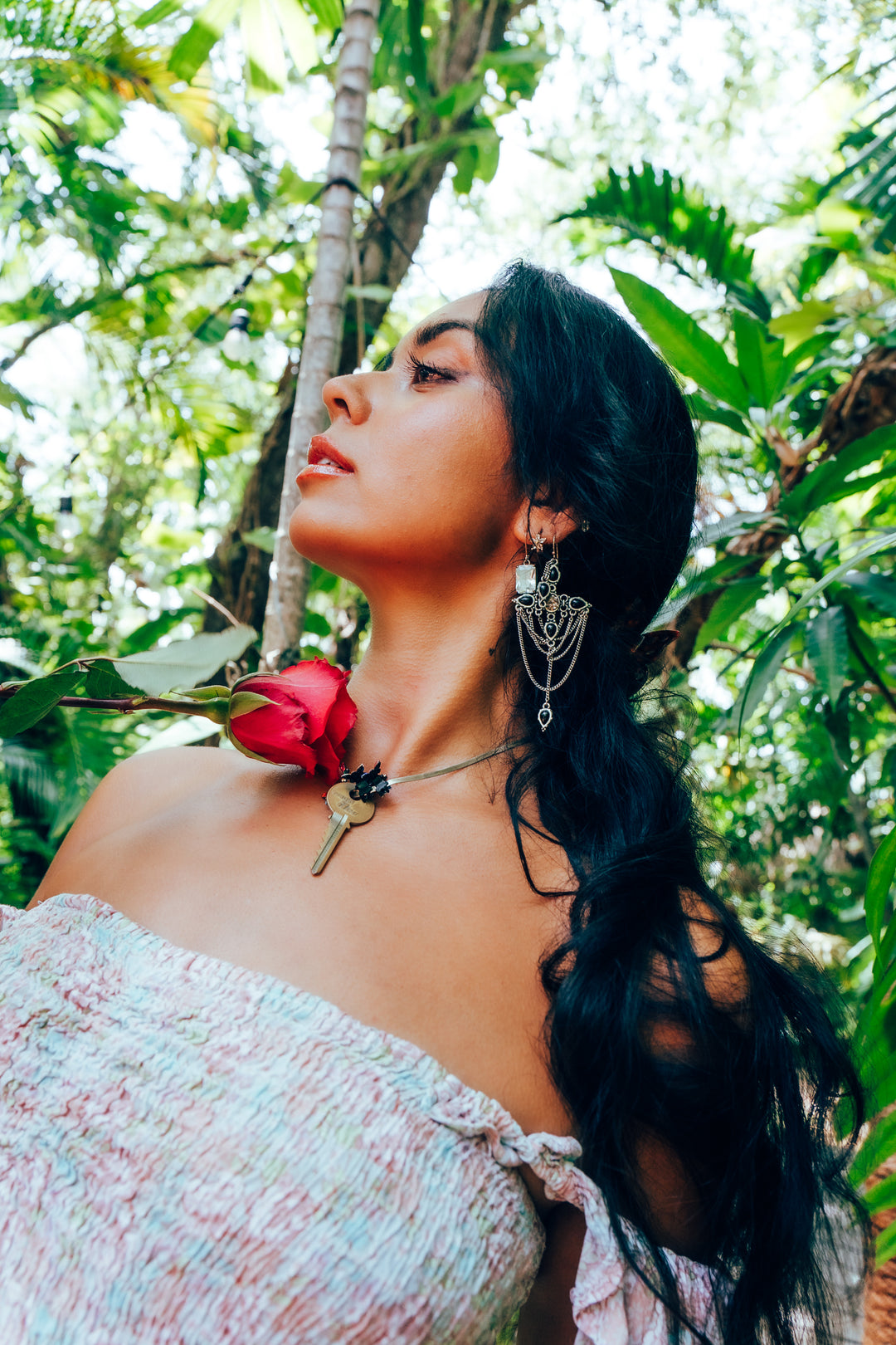 Woman with a hot pink rose in a tropical setting
