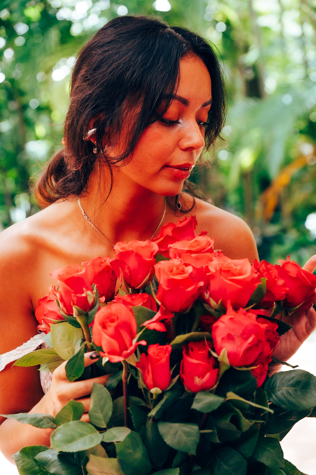 Woman holding a bouquet of hot pink roses in a natural setting